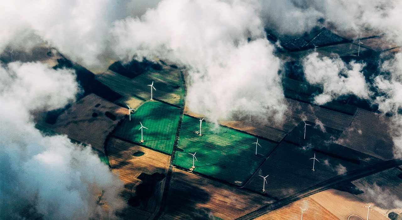 Ventoinhas de energia eólica através de vista aérea representa as nossas soluções para uma gestão mais inteligente e sustentável