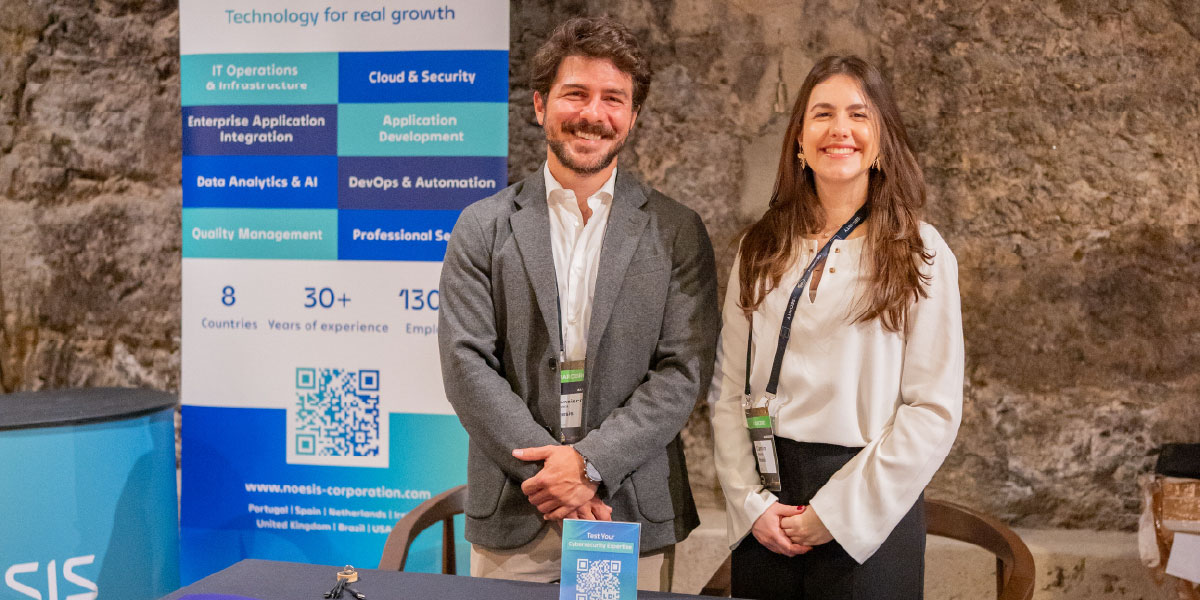 Noesis representatives at the event booth with informational materials