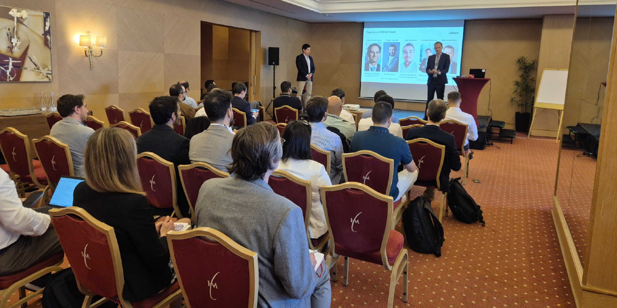 Oradores apresentam conteúdos sobre automação e tecnologia perante uma audiência durante uma sessão UiPath
