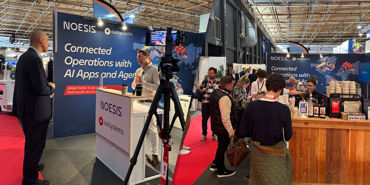 Profissionais conversam no stand da Noesis e da OutSystems durante o Transport & Logistics 2026