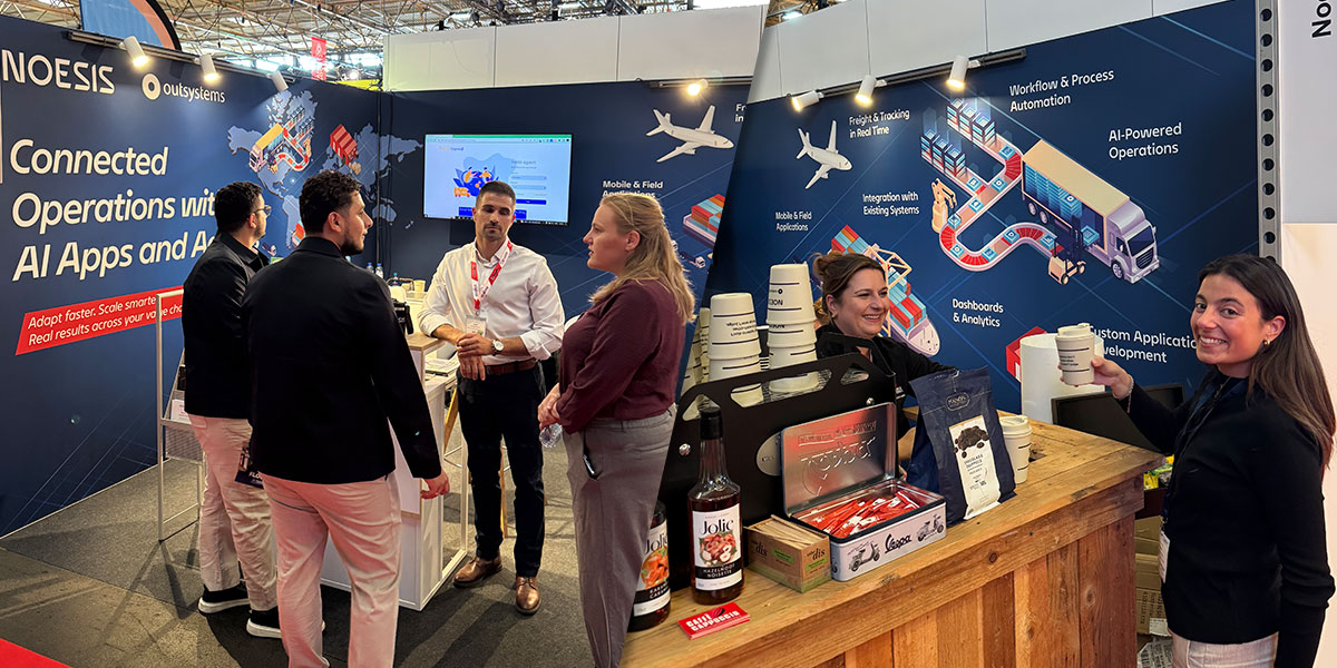 Professionals interacting at the Noesis and OutSystems booth, focused on connected operations with AI