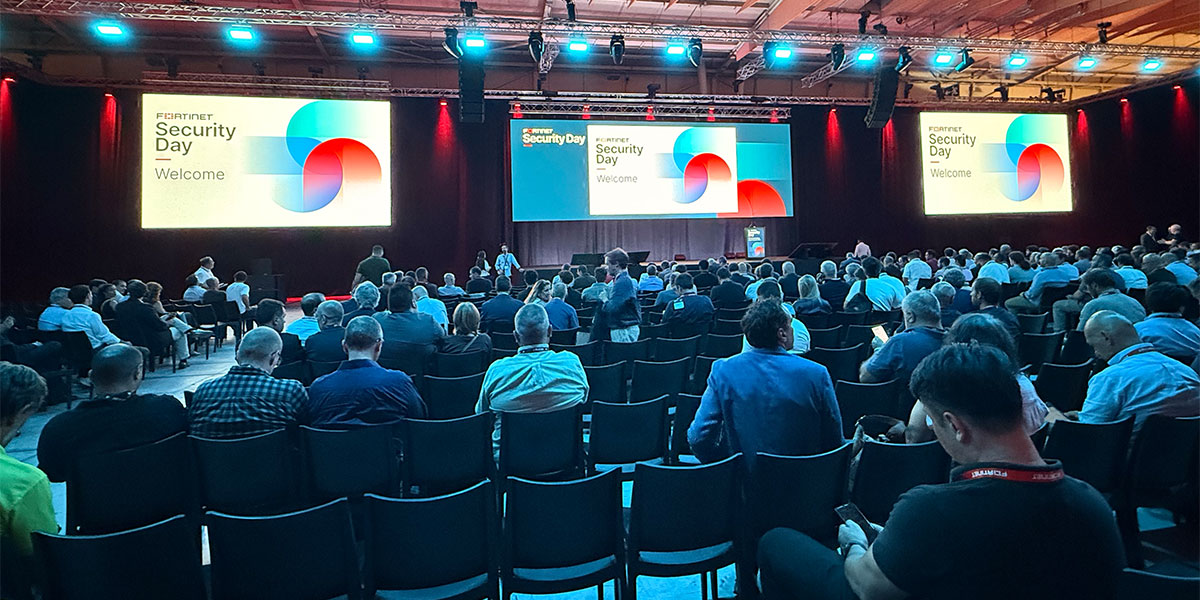 Audience attending the opening session of Fortinet Security Day in an auditorium with presentation screens
