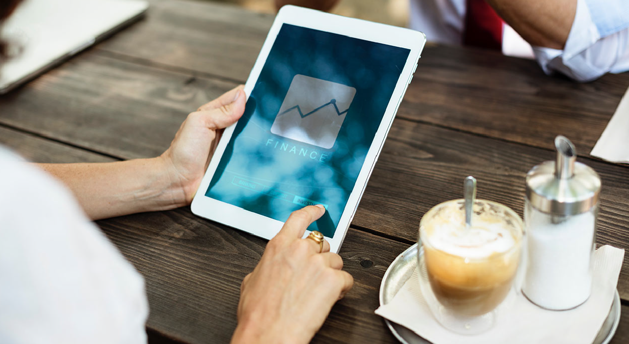 header, Person touching in a tablet at the coffee represents Insights NAV that makes key business indicators available in real-time along with numerous financial analysis options
