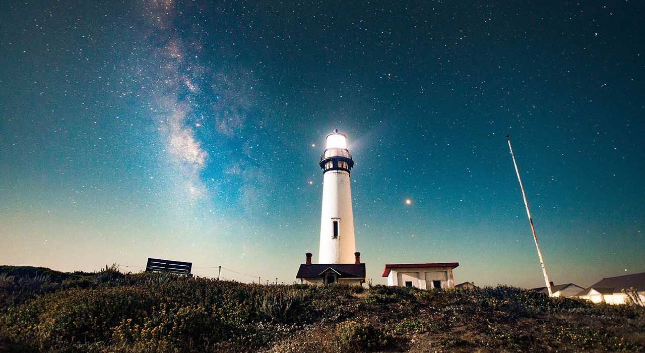 header, Farol iluminado durante a noite representando uma visão 360 de todos os processos e serviços 