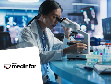 Senhora num laboratório a observar uma amostra através de um microscópio.