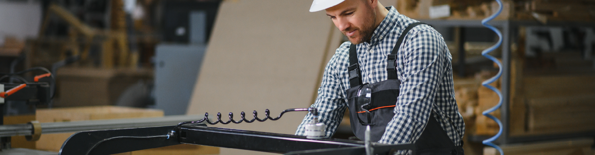 Industrial operator working on an automated production line in a manufacturing facility using production equipment